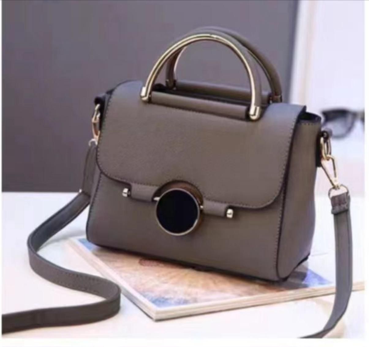 Black handbag with a circle clasp and strap